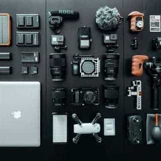 Cette image montre les élèments qu'un voyageurs professionnel enmènent, pc, objectifs etc...